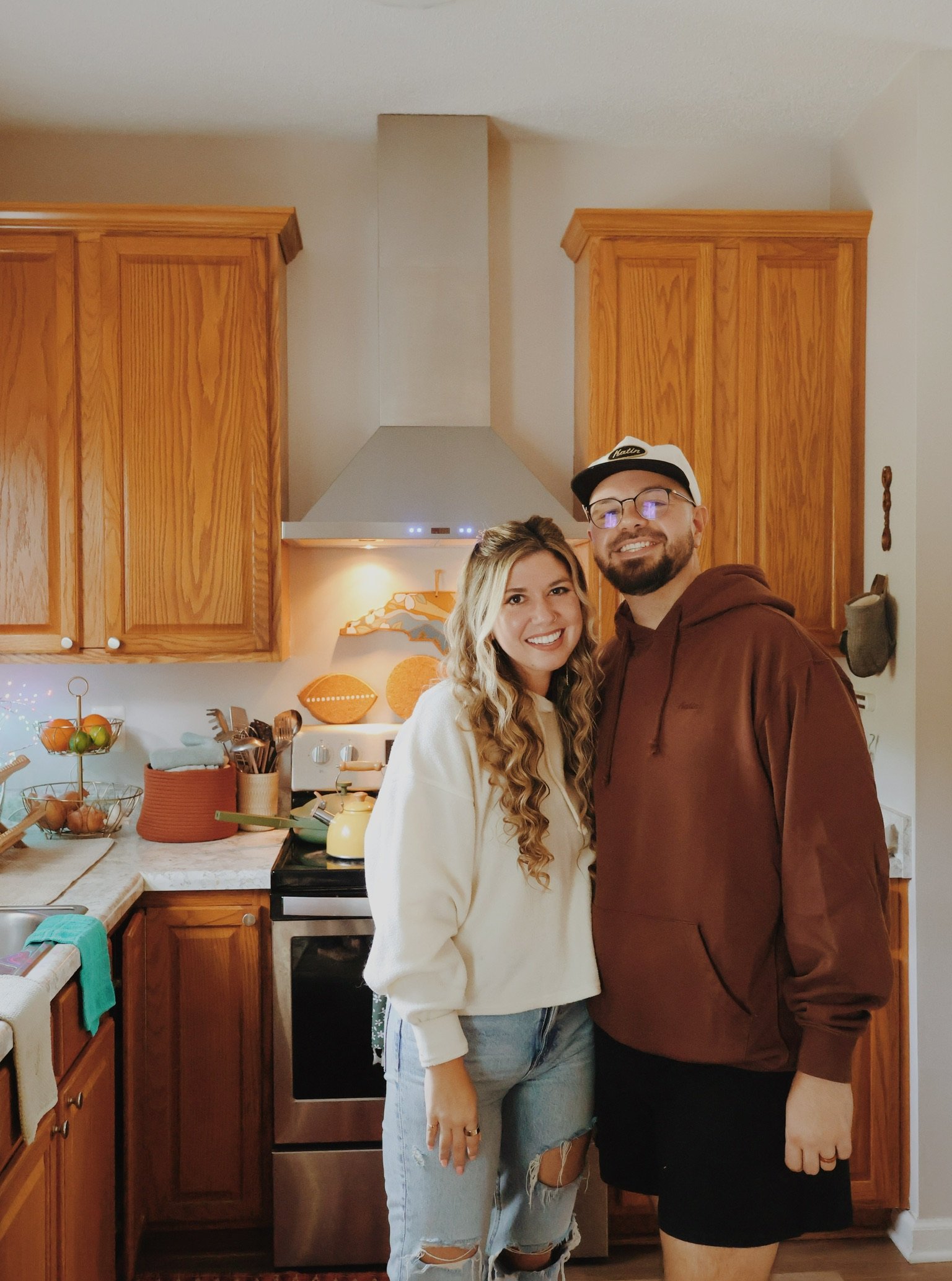 Nicole and Ian standing side by side in the kitchen, smiling.